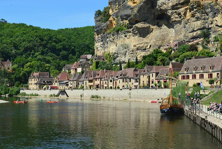 Traditional stone houses of La Roque-Gageac built into cliffs along the Dordogne River in southwestern France