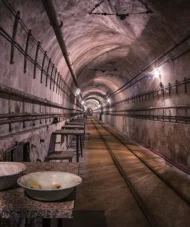 Interior view of a tunnel in the Maginot Line, with arched ceilings and dim lighting.
