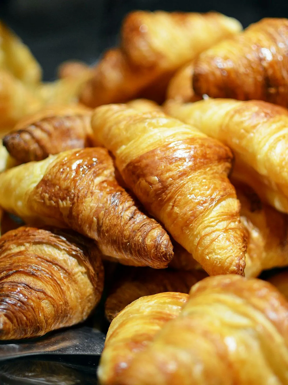 Golden flaky croissants in a Paris bakery window